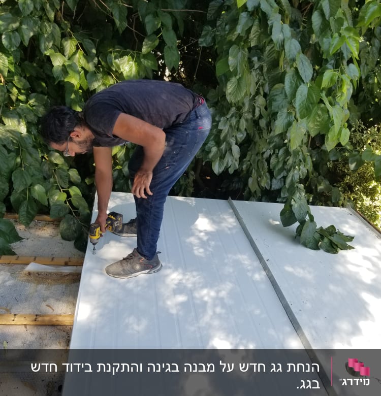 אדם מבריג לוחות מתכת על גג